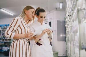 Kobieta i ekspedientka czytają skład produktu kosmetycznego
