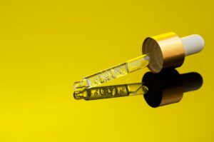 Pipeta z serum z witaminą C na żółtym tle